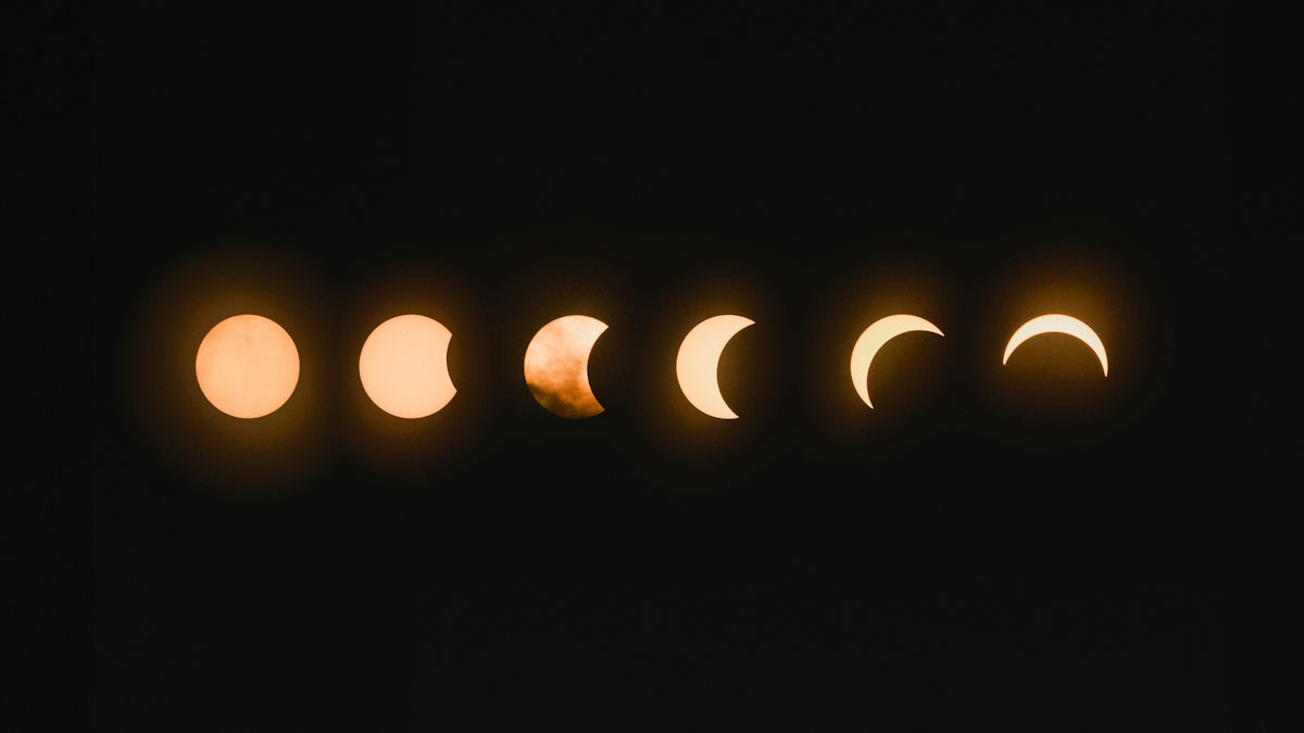 Six phases of a solar eclipse in a horizontal row against a black sky